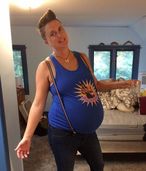 A very pregnant Coach Laura wearing a blue shirt and suspenders.